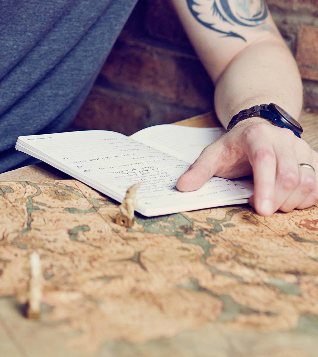 A Brand Adventurer pointing to a map and takign notes